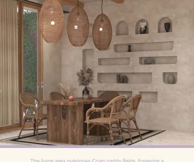Dining room of a private pool villa in Salvador, Goa, with a timber table, woven chairs and plaster niches.